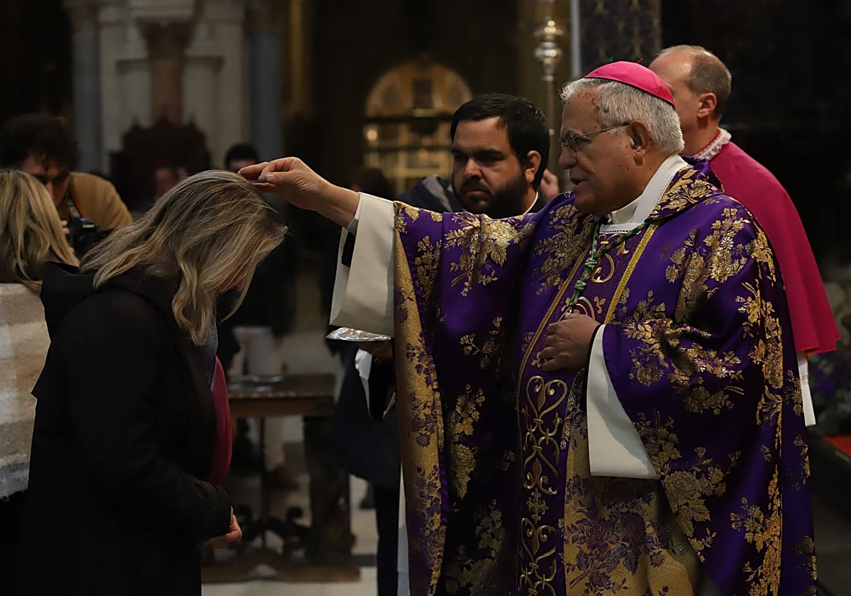 El obispo impone la ceniza a una mujer durante la misa