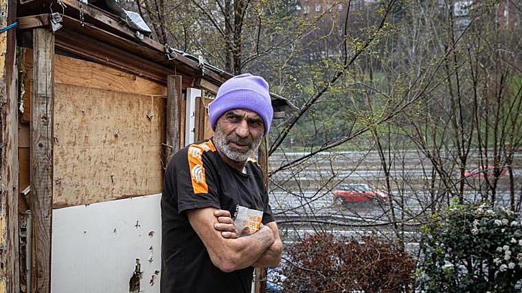 Gianco posa frente a la casa de madera de la M-30 que él mismo construyó