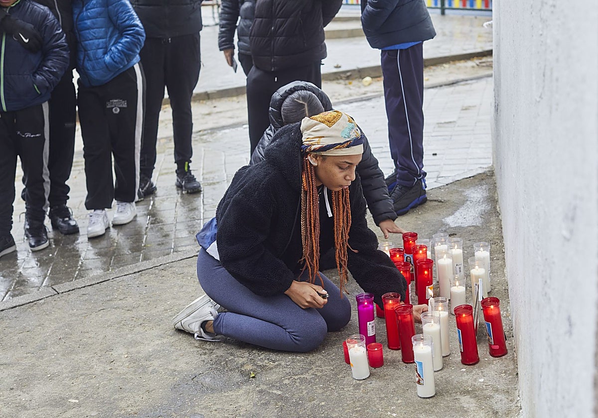 Una joven enciende una vela en el altar en memoria de William