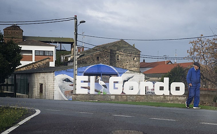 Imagen principal - El Gordo tiene 300 habitantes; muchos empleados en Rheinmetall Expal Munitions. Abajo a la izquierda, vecinos de El Gordo como Josefa y Gonzalo, que hablan del beneficio que deja en el pueblo la empresa. A la derecha, Miguel Blázquez, trabajó treinta años en Expal y dice que «los alemanes son la hostia. Ahora todos los empleados están fijos»