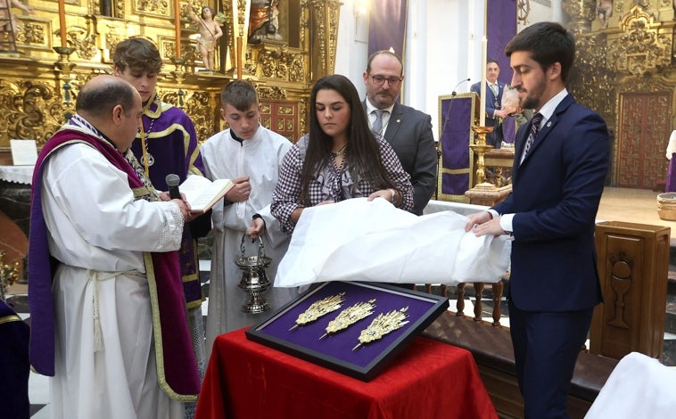 Imagen principal - En la fotografía superior, el momento en que se descubrieron las potencias, ante el párroco y consiliario. Debajo a la izquierda, foto conjunta del grupo joven. A la derecha, el hermano mayor, con los donantes y las piezas ofrecidas este domingo