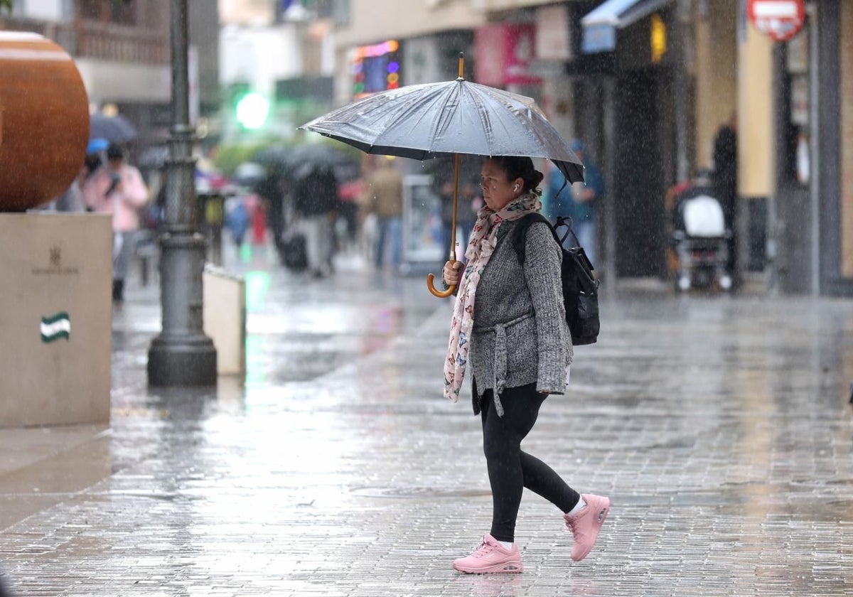 Una mujer por las calles del centro esta pasada semana de lluvias intensas en Córdoba