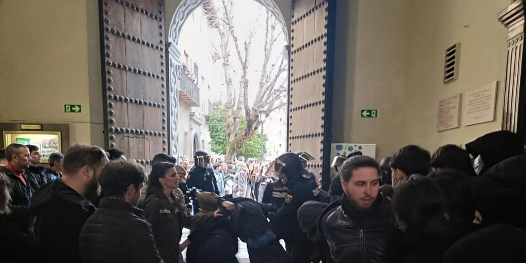 Unos 25 encapuchados intentan boicotear la participación de Macarena Olona en un coloquio en Granada