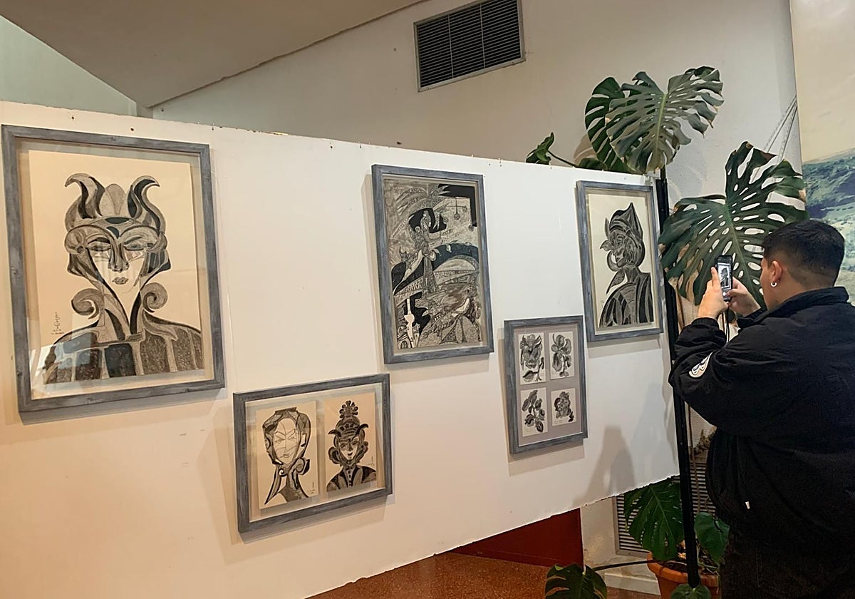 Un asistente fotografía una de las obras de Suzanne Grange