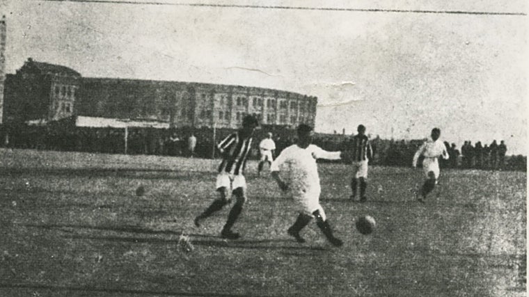 Una jugada de Manolo Prast, acosado por Sócrates Quintana, en un partido de fútbol con la plaza de toros de Goya como fondo, en 1908
