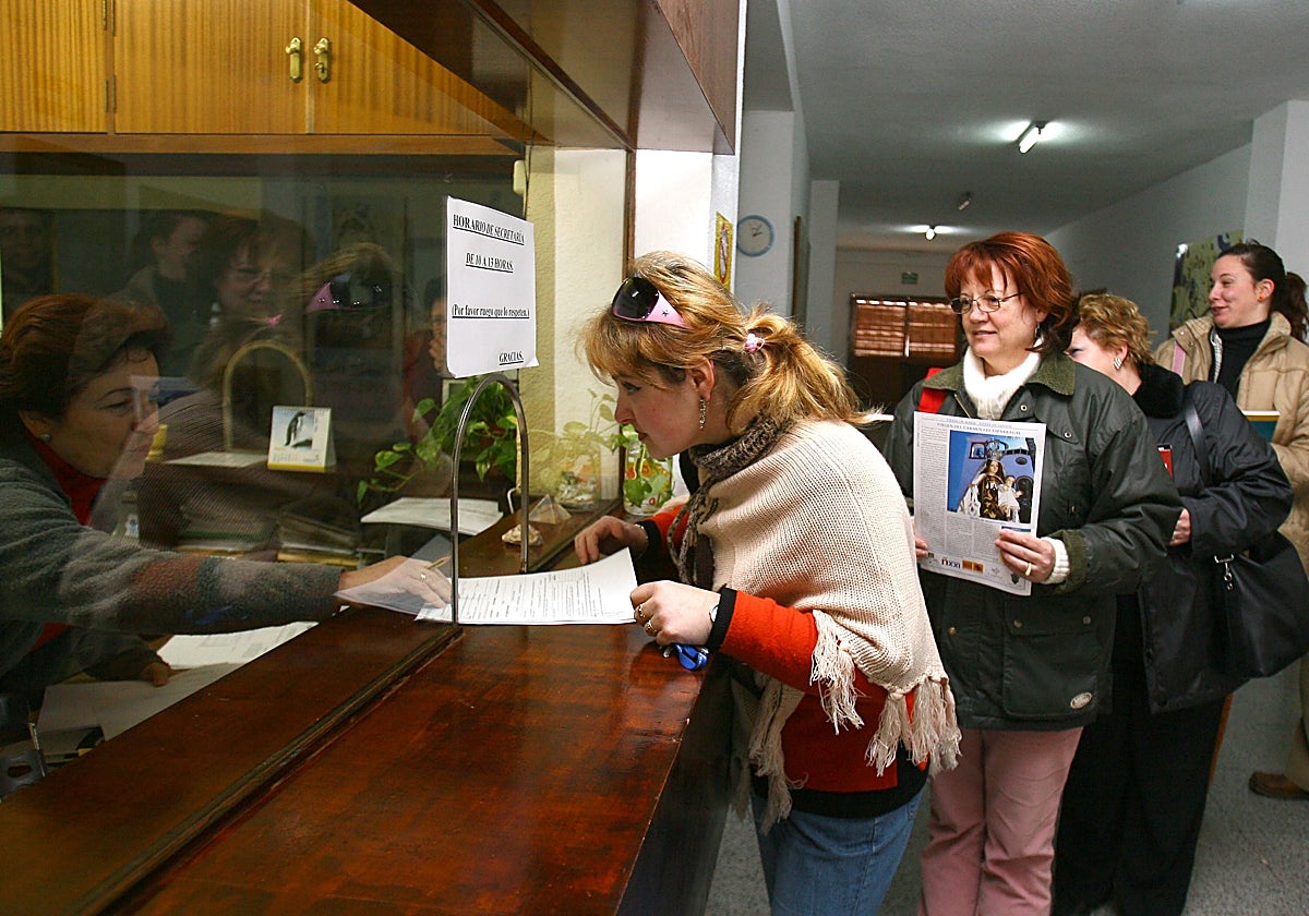 Un grupo de madres en una ventanilla de un colegio de Córdoba presentando documentación