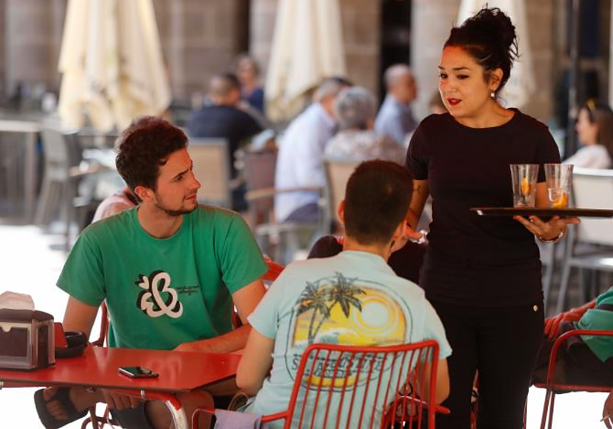 Una empleada de restauración atiende una mesa en Bilbao en foto de archivo