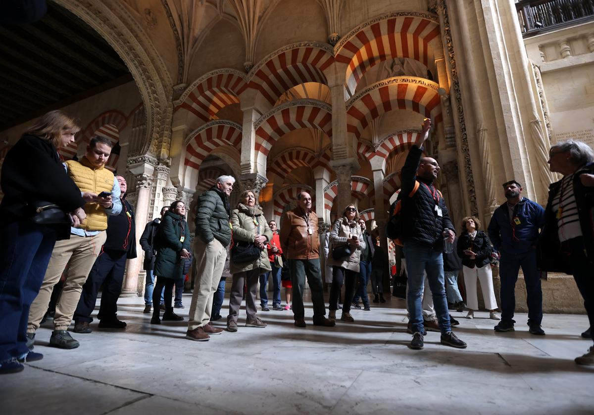 Un grupo de turistas atiende las explicaciones de su guía en la Mezquita-Catedral