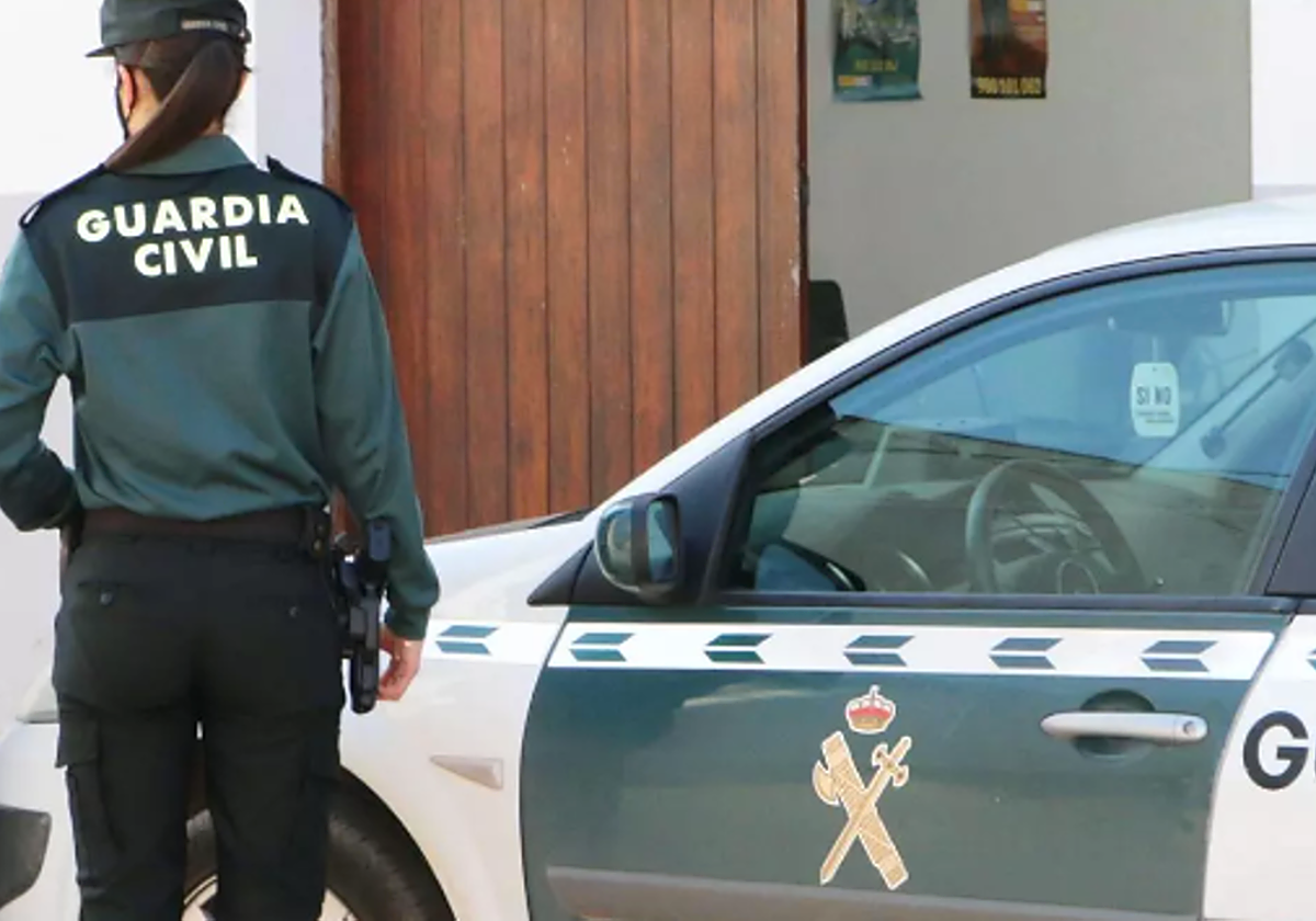 Agente y coche de la Guardia Civil en foto de archivo