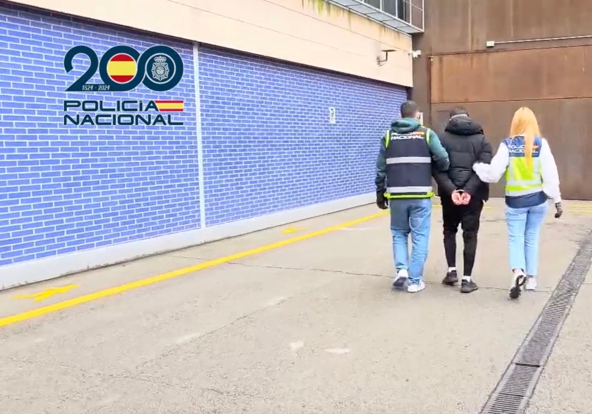 Uno de los detenidos, custodiado por dos agentes
