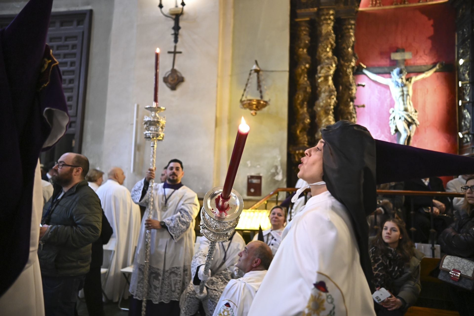 Un penitente de la Hermandad de Tres Caídas apaga su cirio tras regresar al templo.