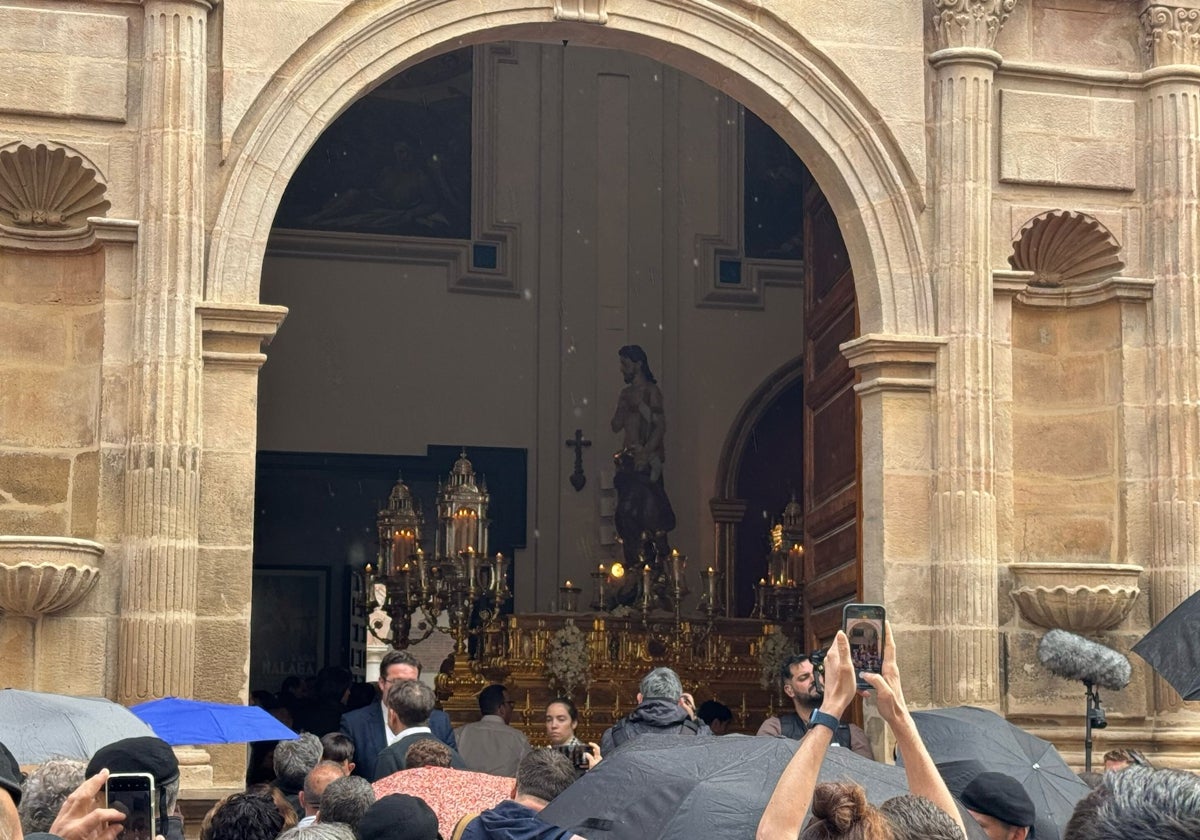 El Resucitado en San Julián con los fieles bajo la lluvia en la calle