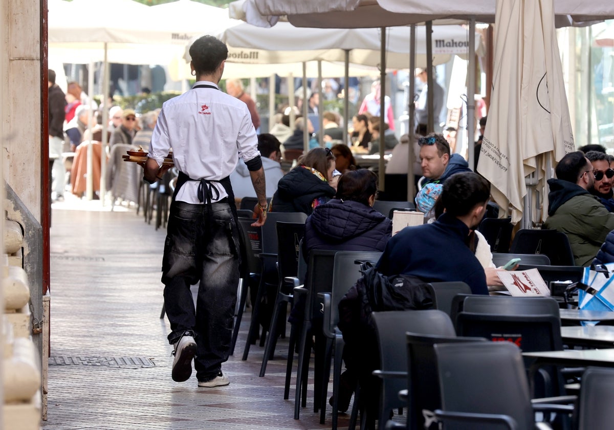 Un camarero presta servicio en una terraza andaluza.