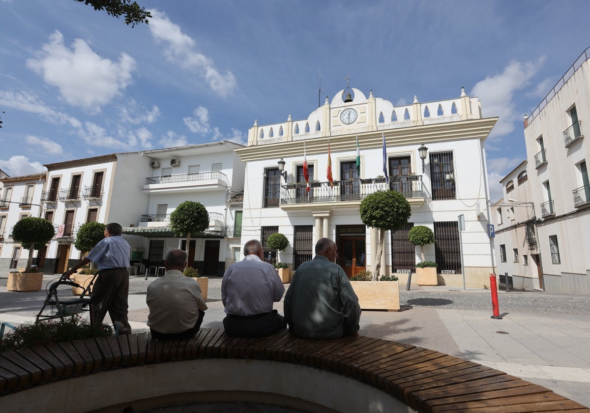 Vecinos de La Rambla sentados en un banco frente al Ayuntamiento