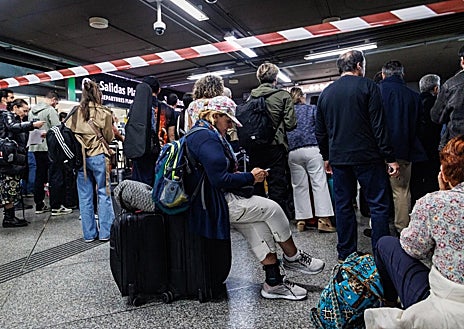 Imagen secundaria 1 - Arriba, Manuela, Hannah, Elvis y Enrique brindan con cerveza tras su regreso a Madrid. Debajo, viajaros a la espera de noticias en Atocha. A la derecha, las hermanas cordobesas Sandra y Marina 