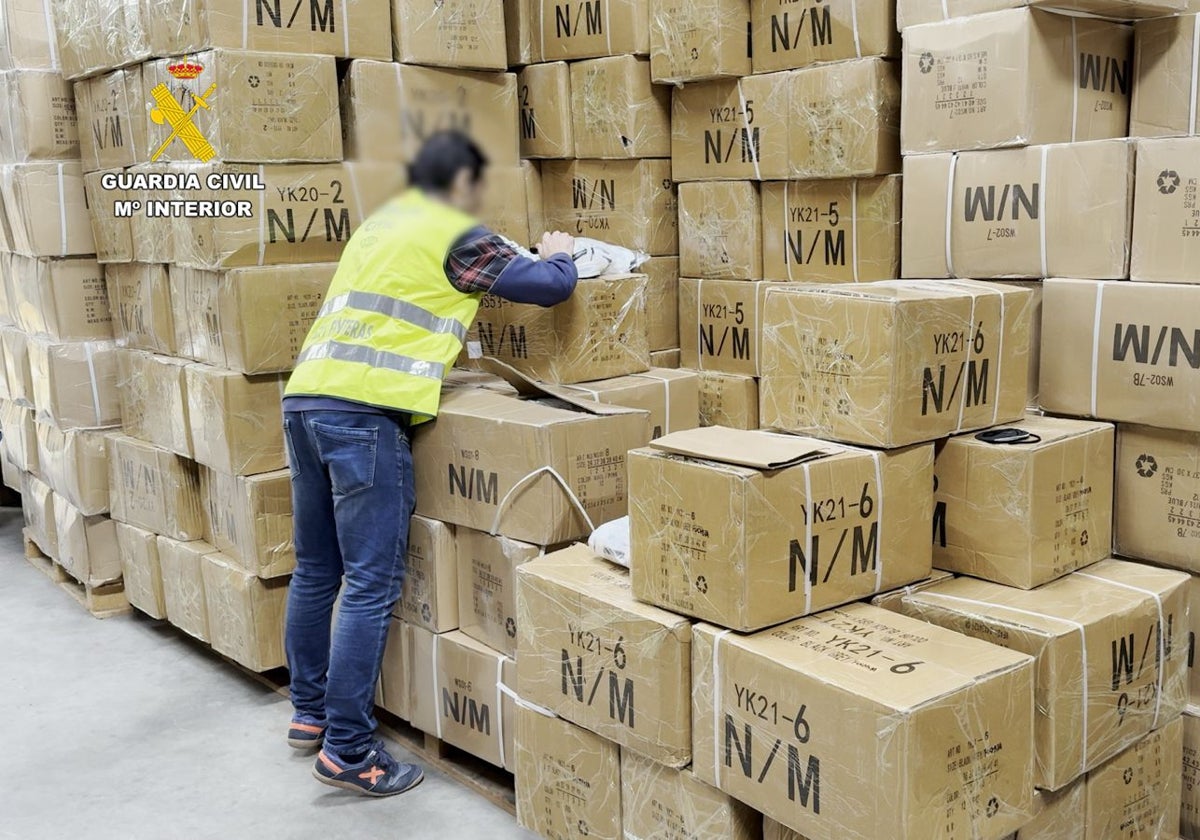 Un agente durante el registro a uno de los almacenes con el material falsificado