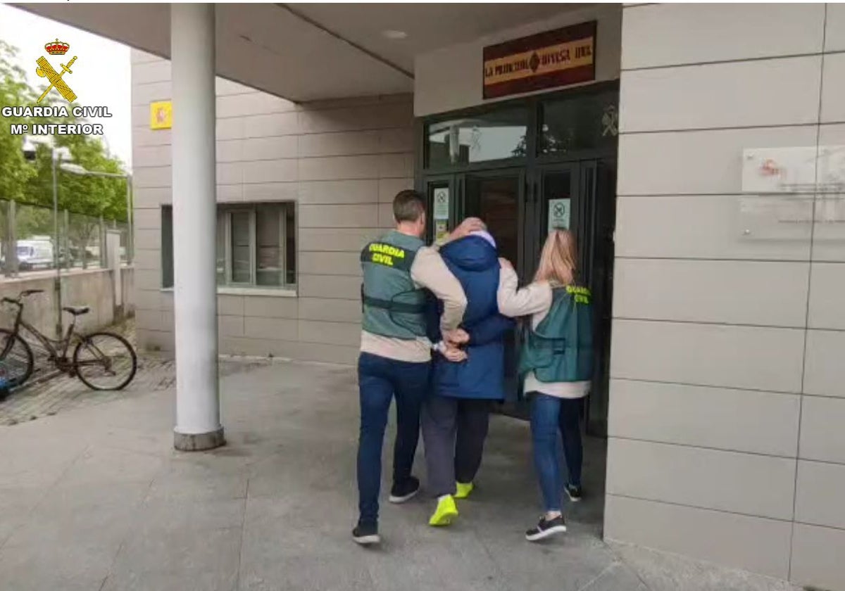 El detenido, con dos agentes, entrando al puesto de la Guardia Civil de Azuqueca