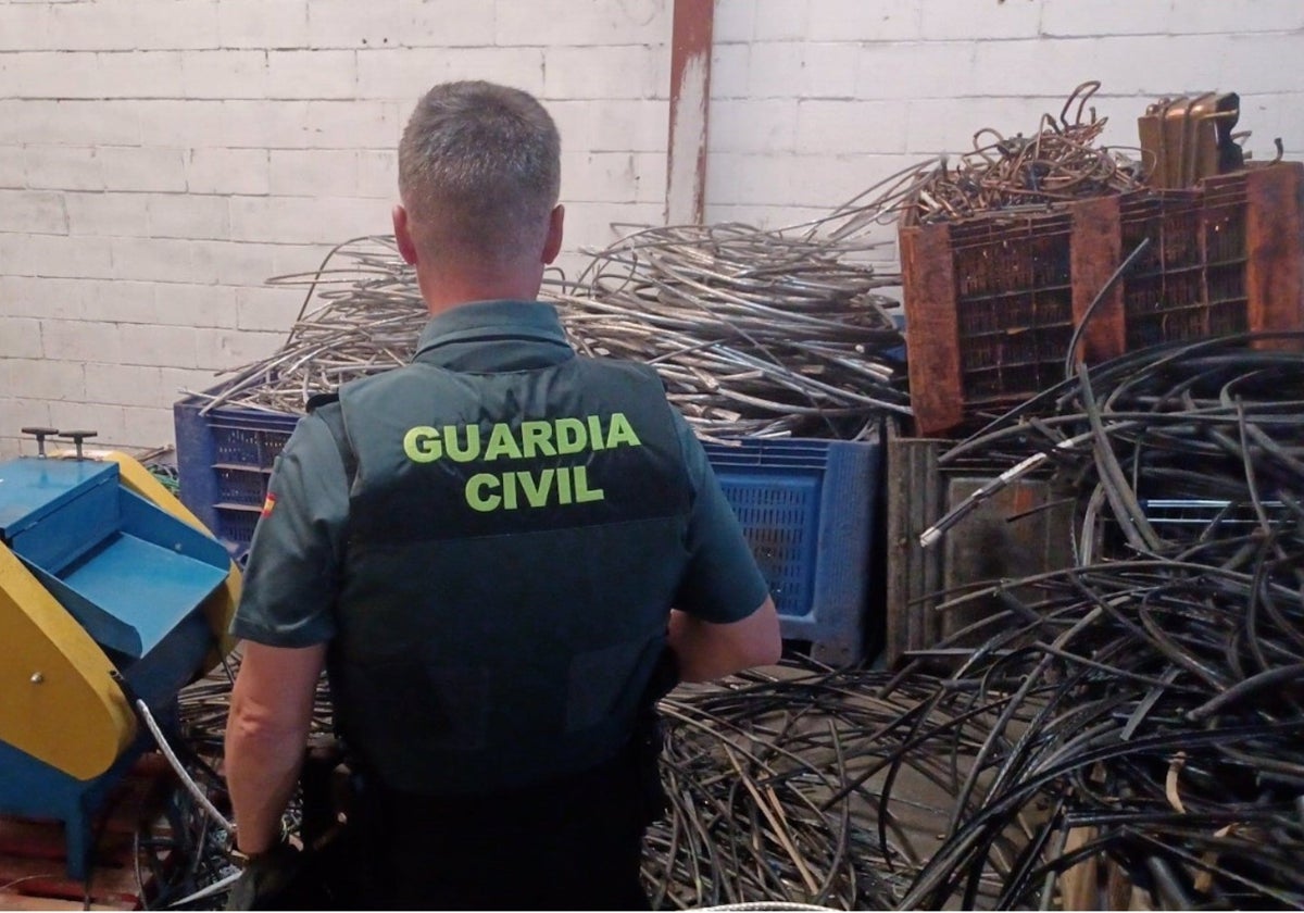 Un agente de la guardia civil frente a los conductores de cable requisados en una operación