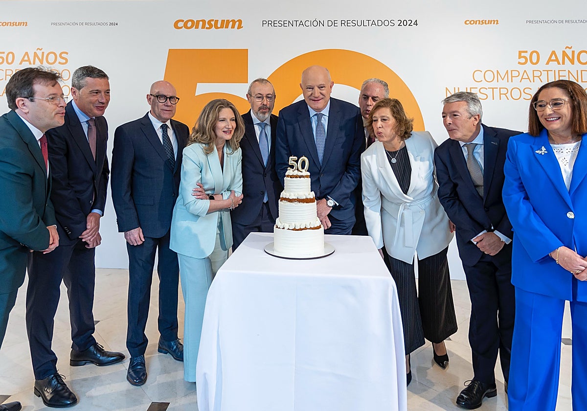 Imagen de los socios de Consum soplando las velas de la tarta por su 50 aniversario
