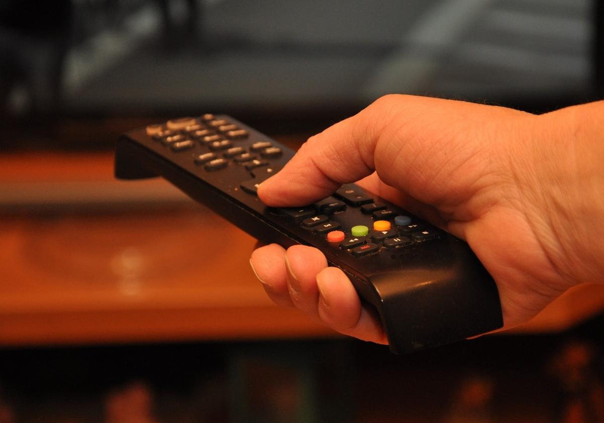 Una persona enciende su televisor