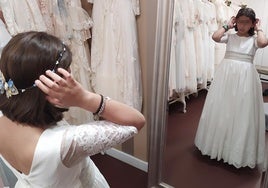 Una niña se prueba su vestido de comunón