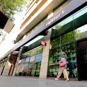 Dos personas caminan por delante de la oficina del banco de la céntrica avenida de Gran Capitán