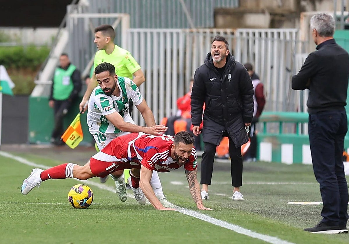 Rubén Alves derriba a un jugador del Granada bajo la mirada de Iván Ania