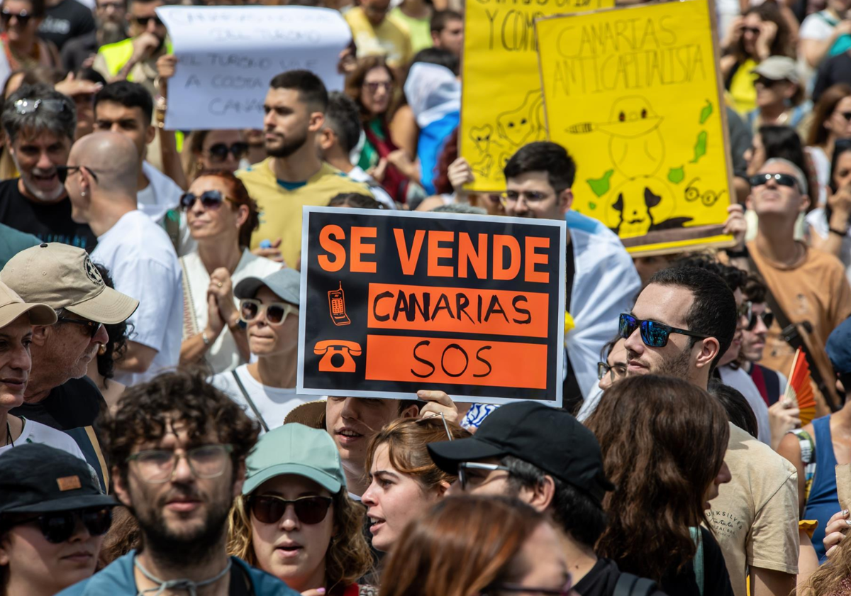 Decenas de personas protestan con carteles durante una manifestación contra el modelo turístico, a 20 de abril de 2024