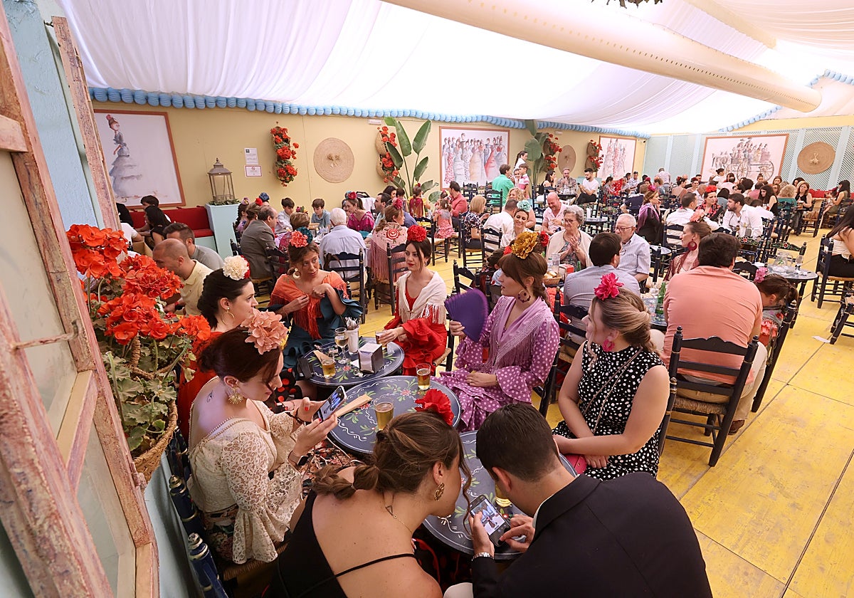 Grupos de familias almuerzan en una caseta de la Feria de Córdoba