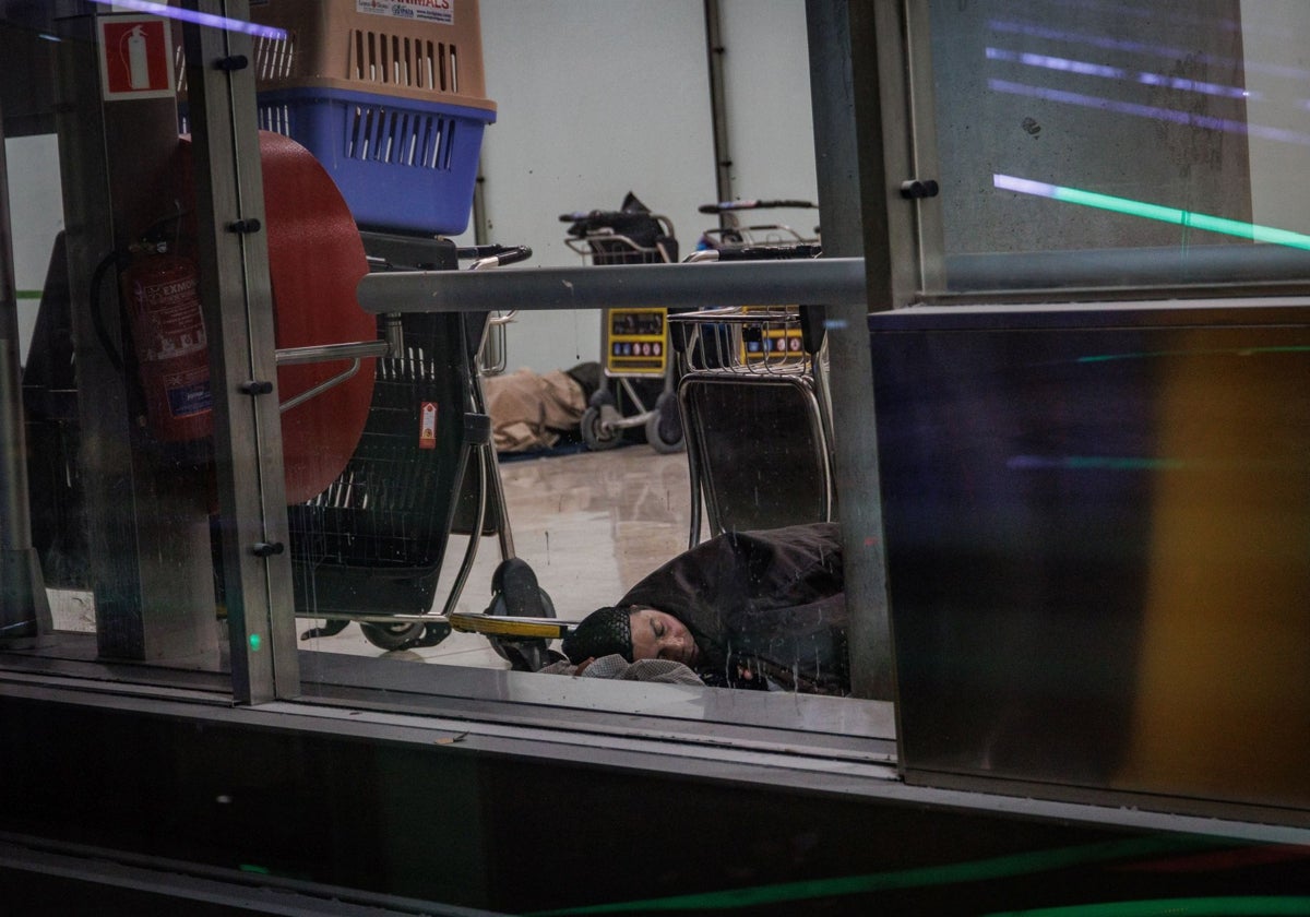 Un indigente duerme en Barajas el pasado 13 de mayo