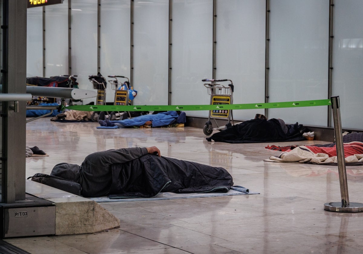 Foto: Decenas de sintecho duermen en la planta 1 de la T4 de Barajas | En vídeo: Los sintecho «borrados» del aeropuerto de Barajas