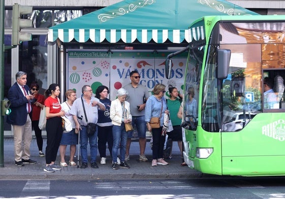 Varias personas esperan su autobús en una parada de Ronda de los Tejares