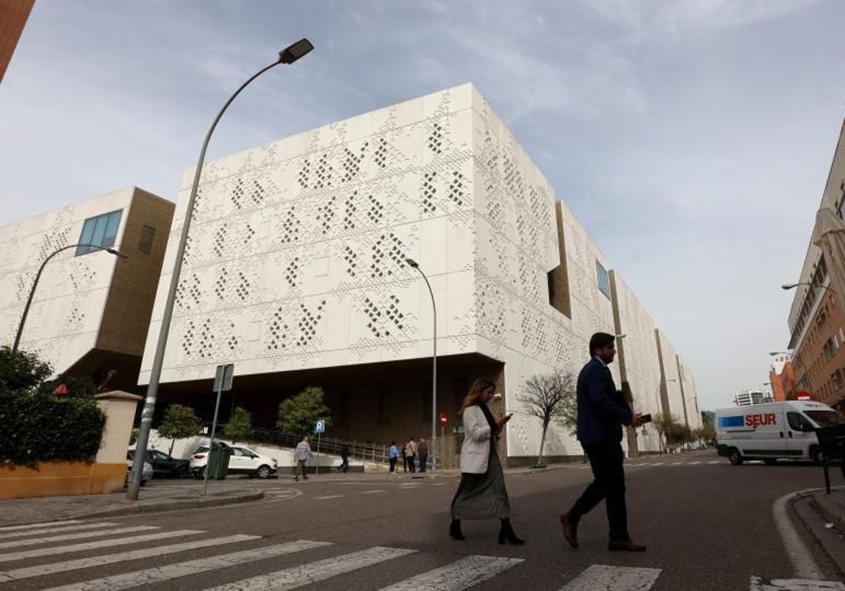 Una pareja cruza por el paso de peatones próximo a la Ciudad de la Justicia