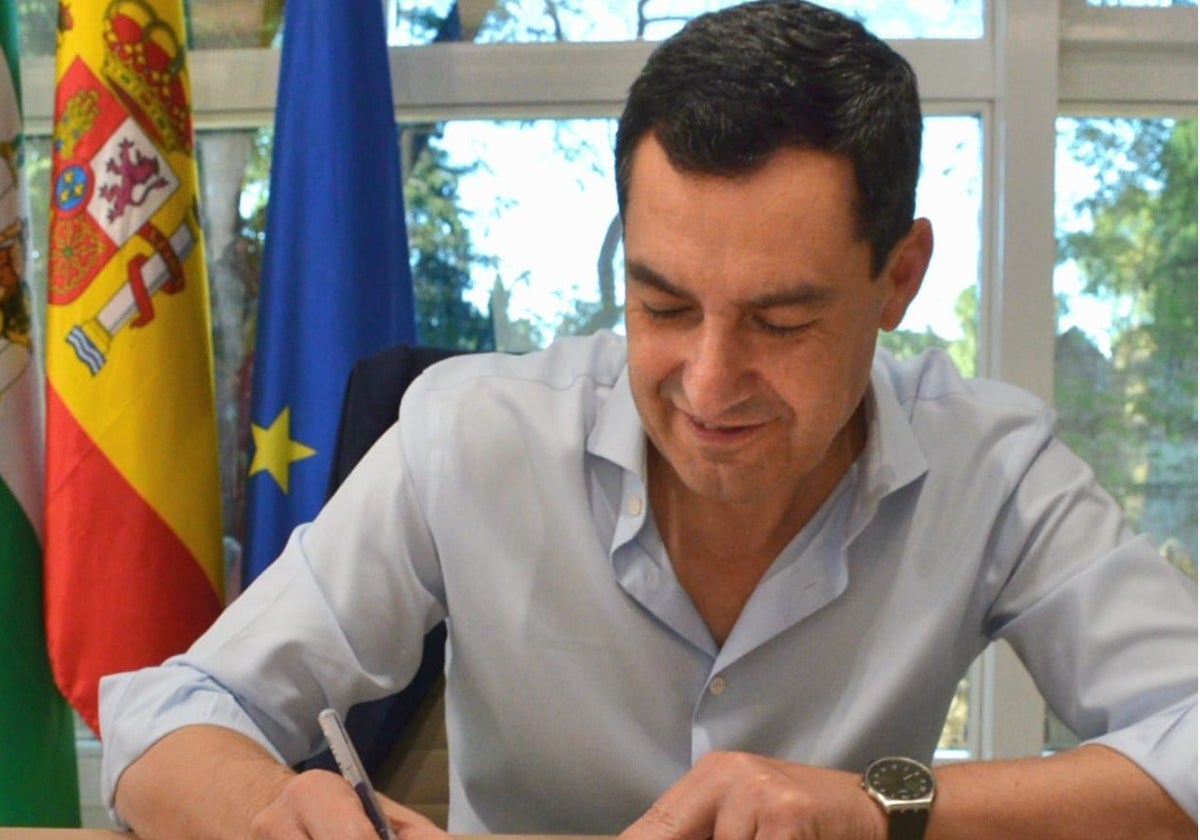El presidente andaluz, Juanma Moreno, firmando el aval