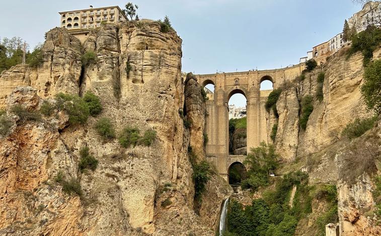 Imagen principal - Arriba, el Puente Nuevo de Ronda. Abajo, a la izquierda, la plaza de toros de la Real Maestranza de Caballería de Ronda; a la derecha, los baños árabes.