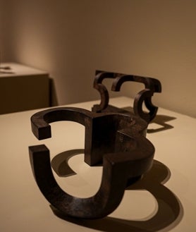Imagen secundaria 2 - Sobre estas líneas, pieza de madera de Chillida en la exposición vallisoletana. Una de sus obras en hierro, el material que más empleó en la década de los 50, y Luis Chillida, hijo del artista, junto al comisario