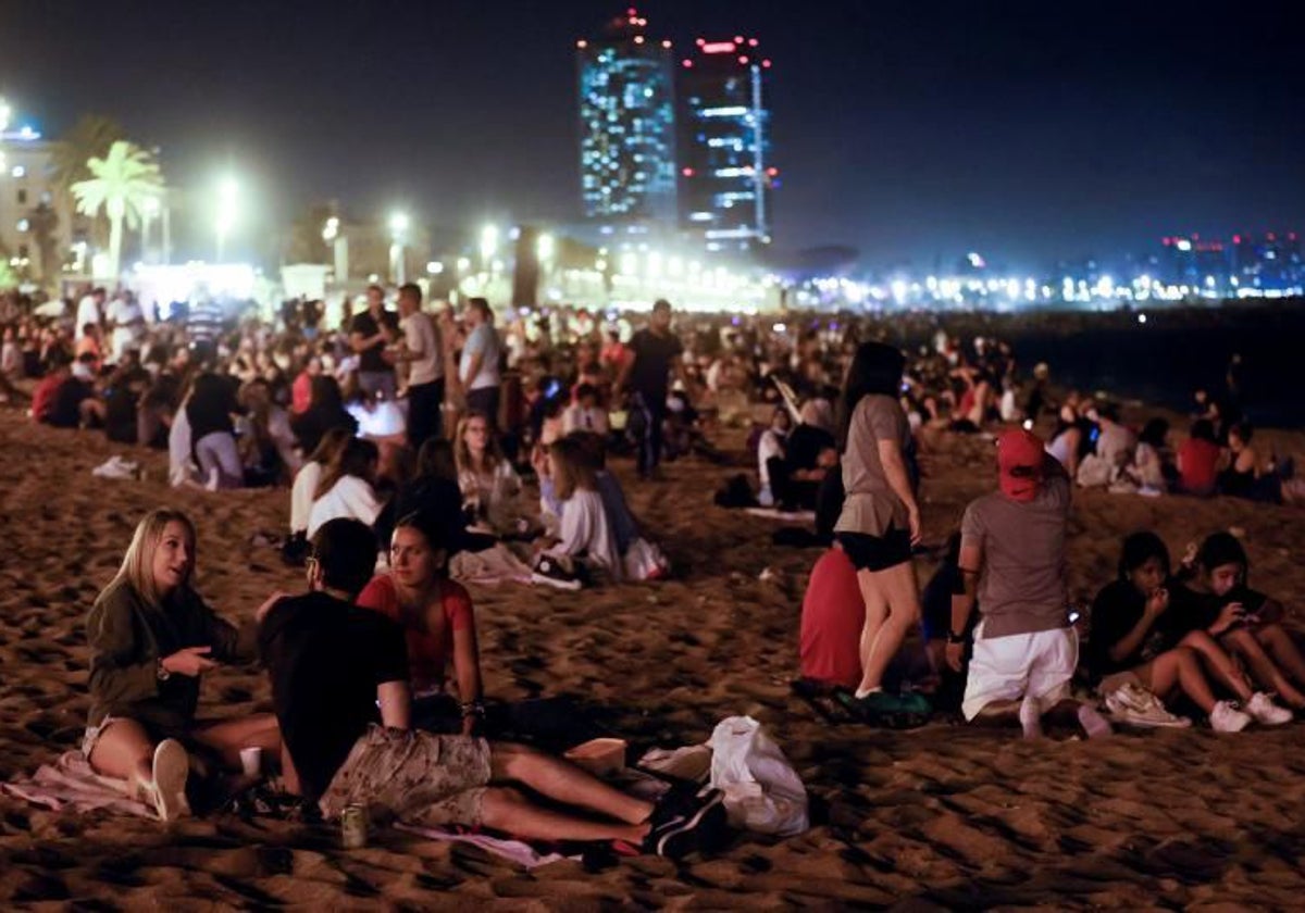 Decenas de jóvenes pasando la noche bebiendo y hablando durante una verbena de San Juan