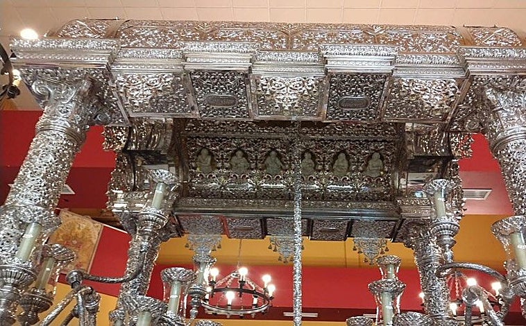 Imagen principal - En la imagen superior, el techo de la carreta del Simpecado de Córdoba, completamente finalizado. Debajo, a la derecha, la vara de promesas. A la derecha, uno de los embellecedores de las ruedas