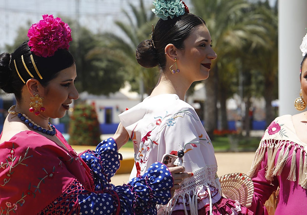 Tres jóvenes vestidas de flamenca en la Feria