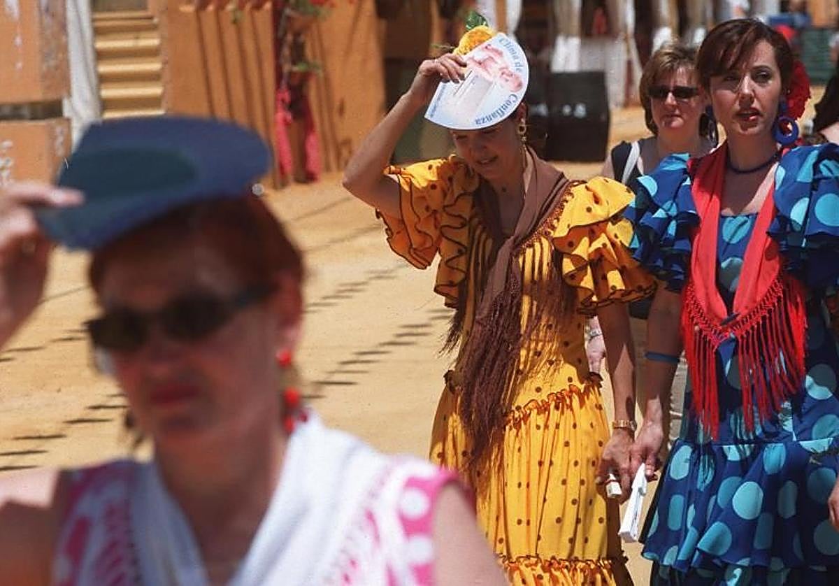 Un grupo de mujeres se protegen del sol con sus abanicos