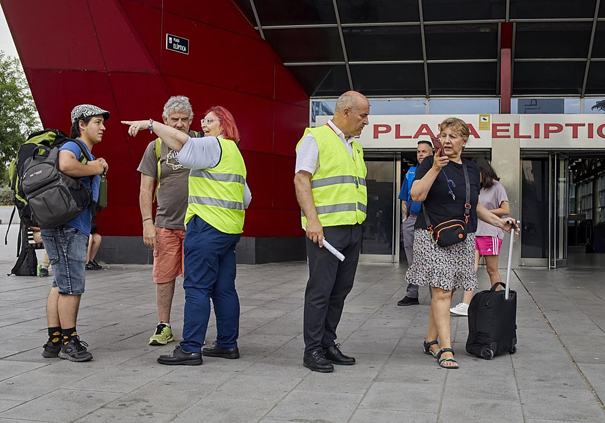 Trabajadores del CRTM indican a los viajeros cómo llegar a sus destinos, en Plaza Elíptica