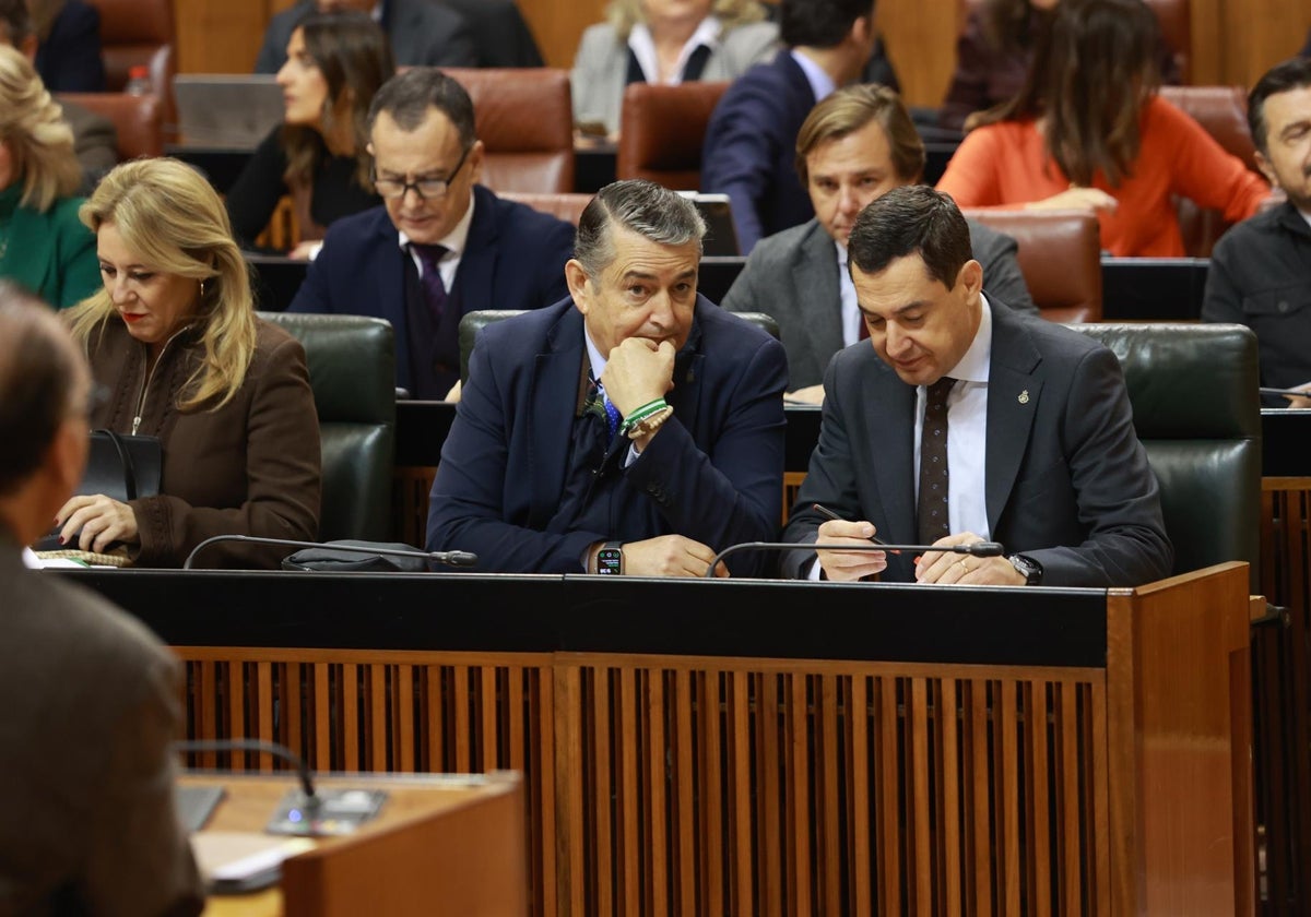 Juanma Moreno (derecha), junto al consejero Antonio Sanz, en un pleno del Parlamento andaluz