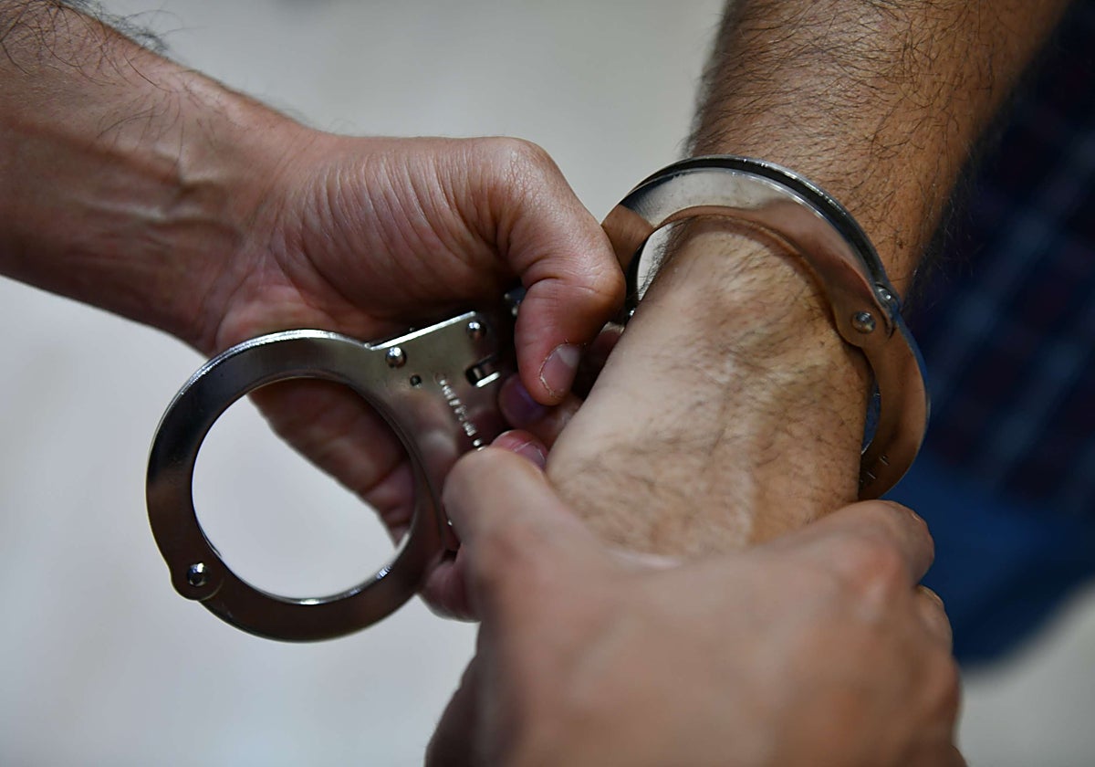 Un agente coloca las esposas a un detenido, en una imagen de archivo