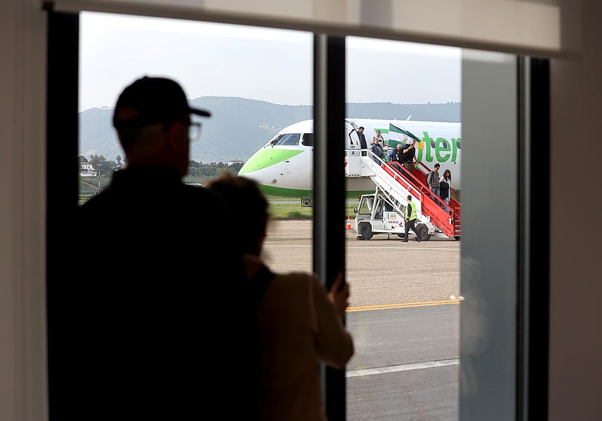 Un par de personas observa la llegada al aeropuerto de Córdoba del primer vuelo de Binter