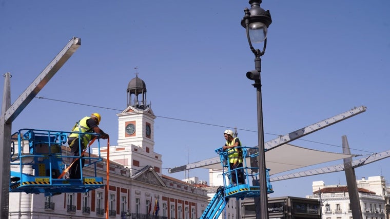 Los operarios ultiman los trabajos de colocación de los toldos