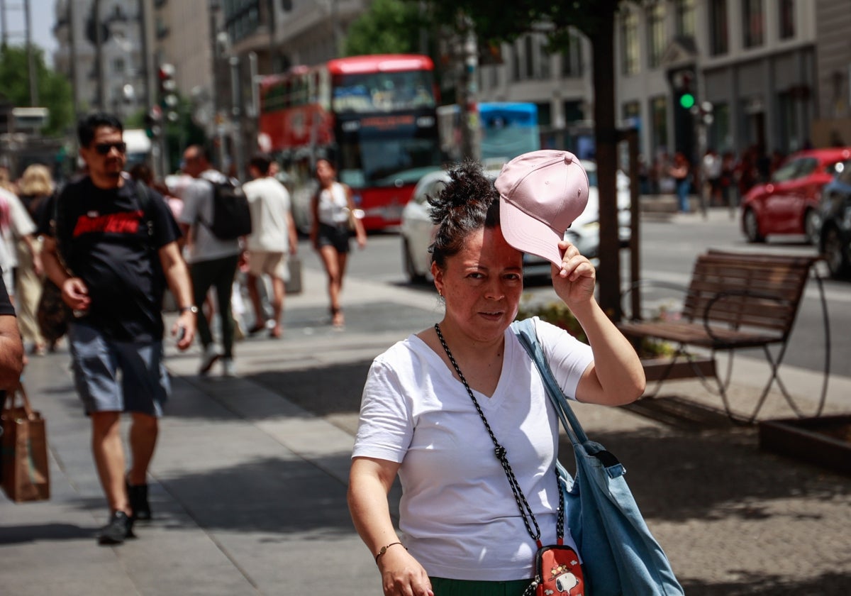Varios turistas pasean por el centro de Madrid en plena ola de calor
