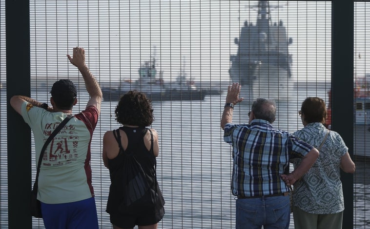 Imagen principal - Vecinos Ceuta se acercaron a la vallas del puerto para ver la llegada de la fragata y del Juan Carlos I, así como la salida de la princesa en la comitiva de seguridad.