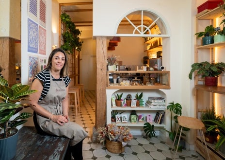 Imagen secundaria 1 - Arriba, Jesús, en el mostrador de esta licorería desde 1902, que antes fue panadería y ultramarinos. Abajo, María Jesús, en la entrada de su café de especialidad, donde, además, vende plantas