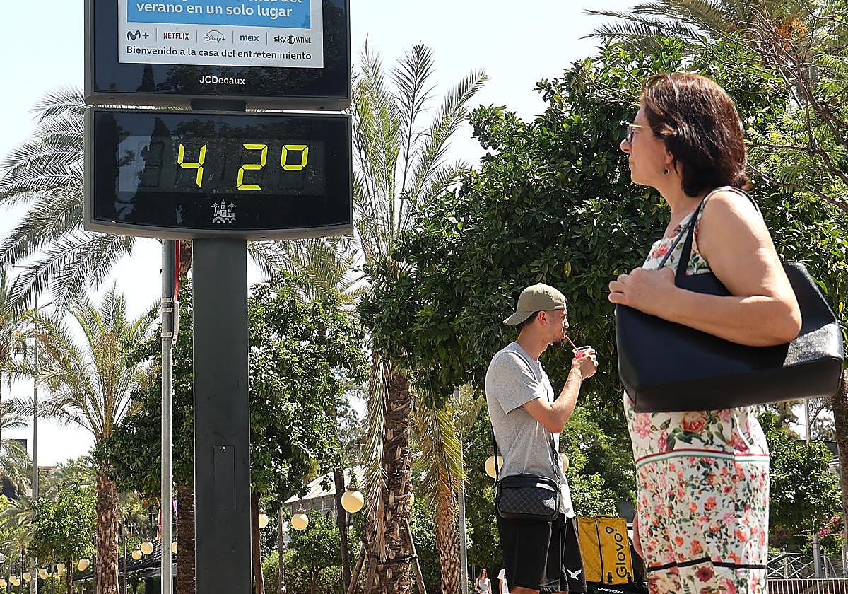Una mujer mira un termómetro en la Victoria durante una ola de calor