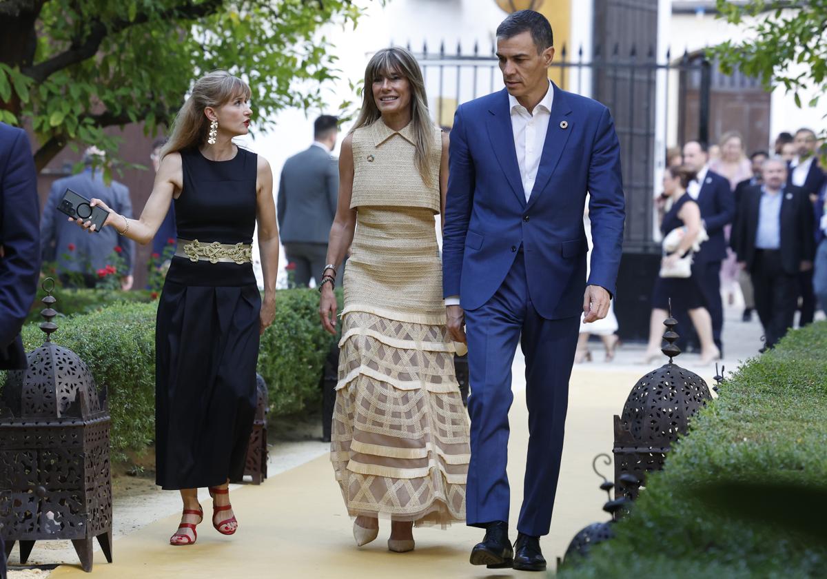 El presidente del Gobierno, Pedro Sánchez (d), junto a su mujer, Begoña Gómez (c), a su llegada a la cena oficial a los participantes en la IV Conferencia Internacional para el Desarrollo de Sevilla.